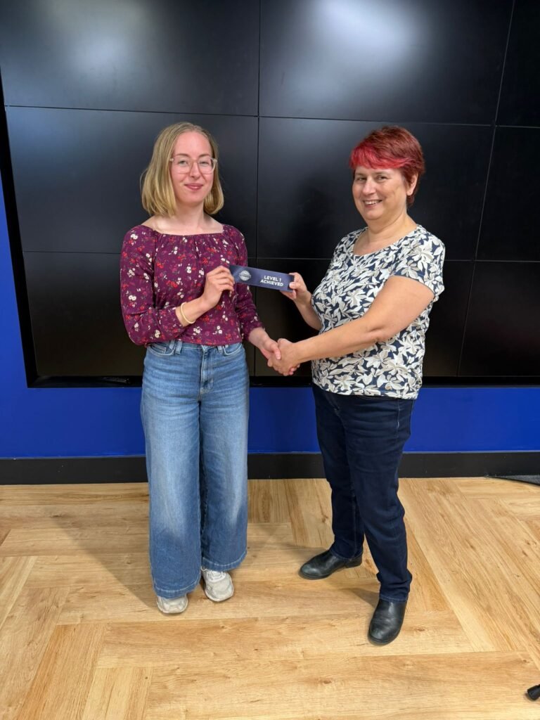 Gemma receiving her level 1 achievement ribbon